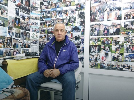 Hido Muratović okružen fotografijama porodica kojima je pomogao 